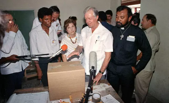 FILE - Former U.S. President Jimmy Carter stands in a polling station at San Miguelito, Panama, as part of an international delegation of observers under the Council of Freely-Elected Heads of Government on May 7, 1989. (AP Photo/Luis Romero, File)