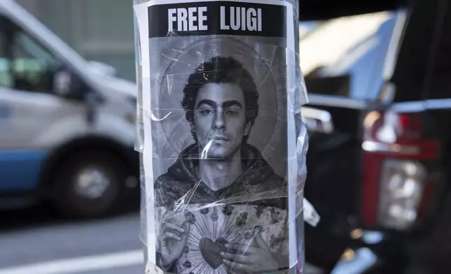 A poster depicting Luigi Mangione hangs outside the New York Hilton Midtown hotel, Thursday, Dec. 12, 2024, in New York. (AP Photo/Julia Demaree Nikhinson)