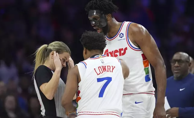 Philadelphia 76ers' Joel Embiid, right, argues with referee Jenna Schroeder, left, as Kyle Lowry intervenes during the first half of an NBA basketball game, Monday, Dec. 23, 2024, in Philadelphia. (AP Photo/Matt Slocum)