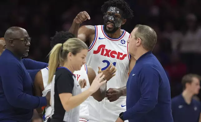 Philadelphia 76ers' Joel Embiid, right, argues with referee Jenna Schroeder during the first half of an NBA basketball game, Monday, Dec. 23, 2024, in Philadelphia. (AP Photo/Matt Slocum)