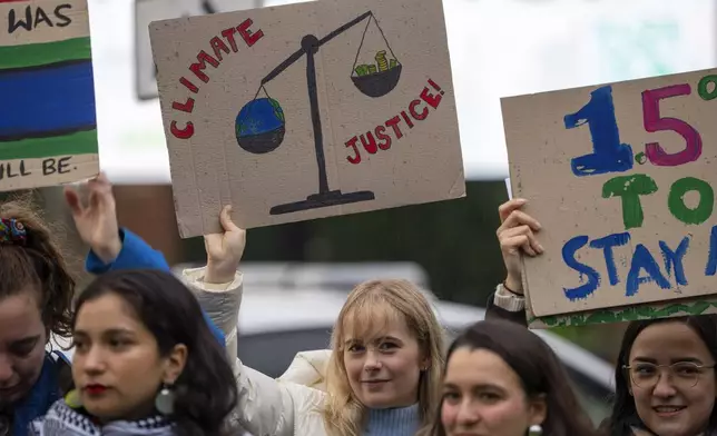 Activists protest outside the International Court of Justice, in The Hague, Netherlands, as it opens hearings into what countries worldwide are legally required to do to combat climate change and help vulnerable nations fight its devastating impact, Monday, Dec. 2, 2024. (AP Photo/Peter Dejong)