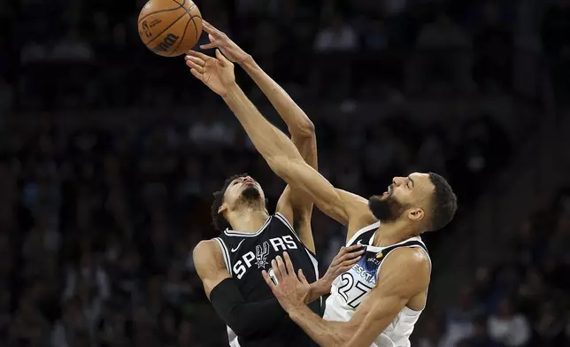 San Antonio Spurs center Victor Wembanyama, left, and Minnesota Timberwolves center Rudy Gobert (27) jump for a tip ball during the first half of an NBA basketball game Sunday, Dec. 29, 2024, in Minneapolis. (AP Photo/Matt Krohn)