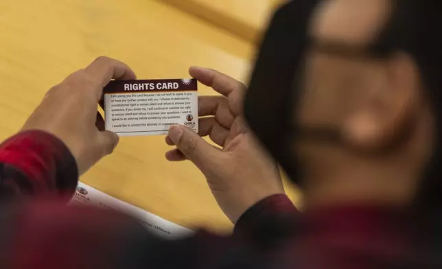 A participant holds a "rights card" during a bilingual workshop for immigrants who want to stay in the United States at the office of the Coalition for Humane Immigrant Rights organization in Los Angeles, Wednesday, Dec. 4, 2024. (AP Photo/Jae C. Hong)