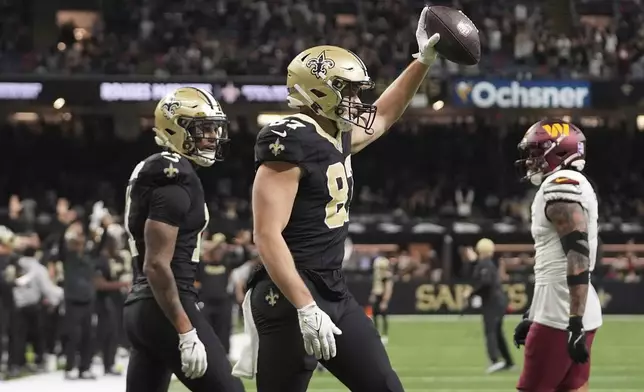 New Orleans Saints tight end Foster Moreau (87) celebrates after he makes a catch in the second half of an NFL football game against the Washington Commanders in New Orleans, Sunday, Dec. 15, 2024. (AP Photo/Gerald Herbert)