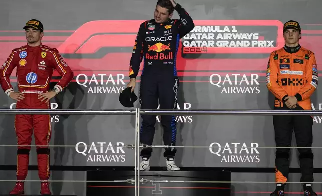 From the left, second-aced Ferrari driver Charles Leclerc of Monaco, first-placed Red Bull driver Max Verstappen of the Netherlands, and third-placed McLaren driver Oscar Piastri of Australia stand on the podium during the Qatar Formula One Grand Prix at the Lusail International Circuit in Lusail, Qatar, Sunday, Dec. 1, 2024. (AP Photo/Altaf Qadri)