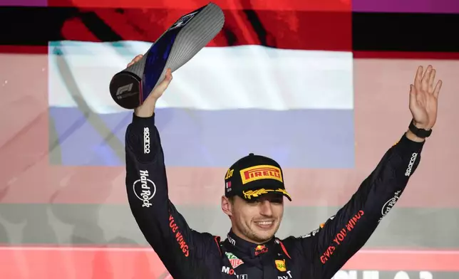 Red Bull driver Max Verstappen of the Netherlands stands on the podium after winning the Qatar Formula One Grand Prix at the Lusail International Circuit in Lusail, Qatar, Sunday, Dec. 1, 2024. (AP Photo/Darko Bandic)