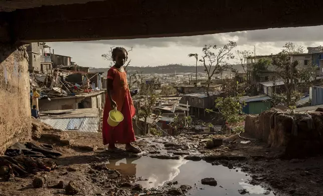 A young girl walks in the Kaweni slum on the outskirts of Mamoudzou, in the French Indian Ocean island of Mayotte, Thursday, Dec. 19, 2024, after Cyclone Chido. (AP Photo/Adrienne Surprenant)