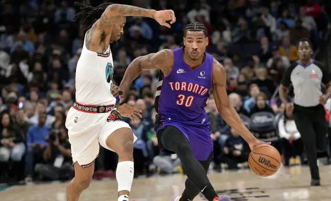 Toronto Raptors guard Ochai Agbaji (30) handles the ball against Memphis Grizzlies guard Ja Morant in the first half of an NBA basketball game Thursday, Dec. 26, 2024, in Memphis, Tenn. (AP Photo/Brandon Dill)