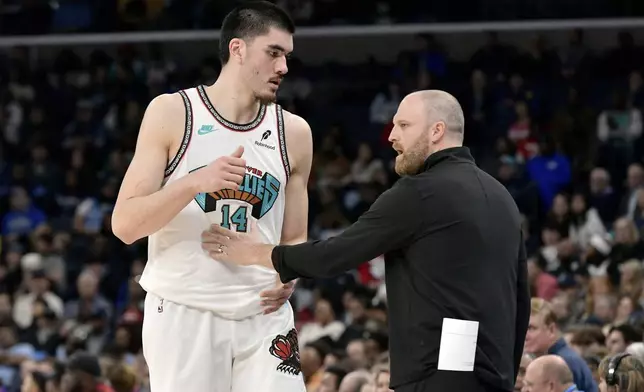 Memphis Grizzlies head coach Taylor Jenkins, right, talks with center Zach Edey (14) in the first half of an NBA basketball game against the Toronto Raptors, Thursday, Dec. 26, 2024, in Memphis, Tenn. (AP Photo/Brandon Dill)