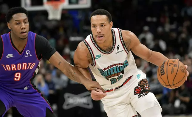 Memphis Grizzlies guard Desmond Bane (22) handles the ball against Toronto Raptors guard RJ Barrett (9) in the second half of an NBA basketball game Thursday, Dec. 26, 2024, in Memphis, Tenn. (AP Photo/Brandon Dill)