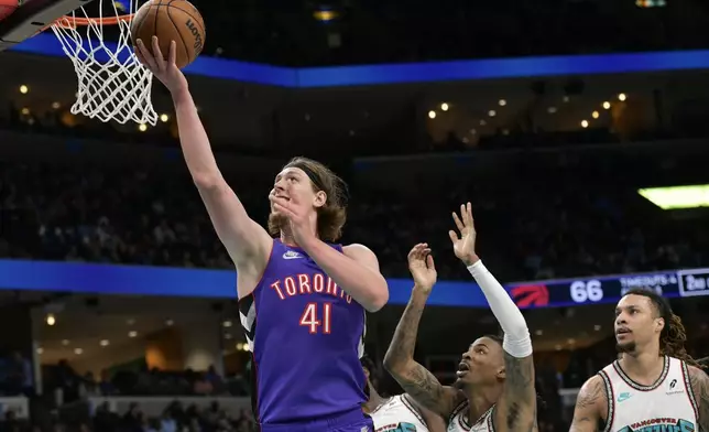 Toronto Raptors forward Kelly Olynyk (41) shoots ahead of Memphis Grizzlies guard Ja Morant, second from right, and forward Brandon Clarke, right, in the first half of an NBA basketball game Thursday, Dec. 26, 2024, in Memphis, Tenn. (AP Photo/Brandon Dill)