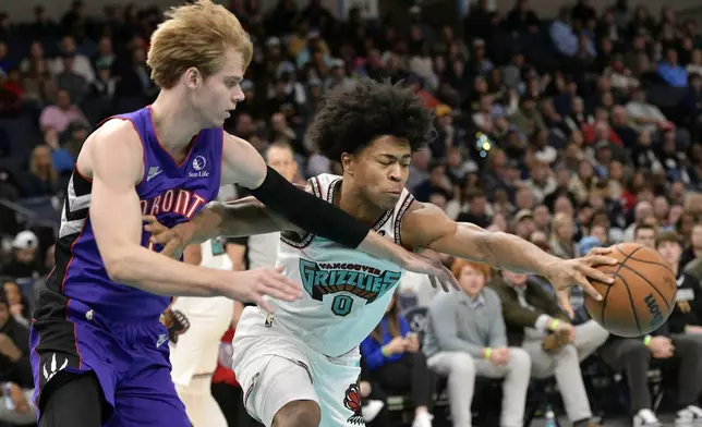 Memphis Grizzlies forward Jaylen Wells (0) and Toronto Raptors guard Gradey Dick struggle for control of the ball in the first half of an NBA basketball game Thursday, Dec. 26, 2024, in Memphis, Tenn. (AP Photo/Brandon Dill)