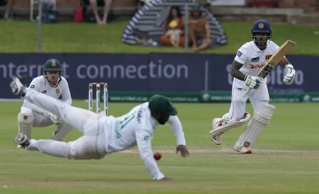 Sri Lanka's Pathum Nissanka, right, makes a run as South Africa's captain Temba Bavuma, tries to field off the ball during the second day of the second Test cricket match between South Africa and Sri Lanka, at St George's Park in Gqeberha, South Africa, Friday, Dec. 6, 2024. (AP Photo/Themba Hadebe)
