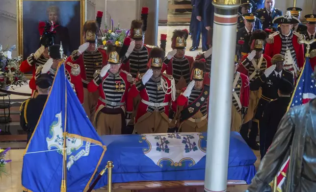 Members of the First Company Governor's Foot Guard pay their respects to the former Governor M. Jodi Rell as she lays in state at the Connecticut State Capitol in Hartford, Conn., Tuesday, Dec. 3, 2024. (Aaron Flaum/Hartford Courant via AP)