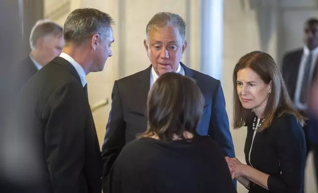 Gov. Ned Lamont and Lt. Governor Susan Bysiewicz talks with Micheal and Maura Rell after paying their respects to the former Governor M. Jodi Rell as she lays in state at the Connecticut State Capitol in Hartford, Conn., Tuesday, Dec. 3, 2024. (Aaron Flaum/Hartford Courant via AP)