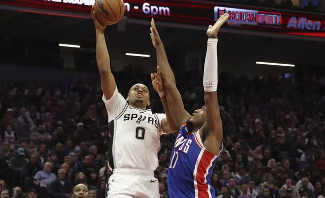 San Antonio Spurs forward Keldon Johnson (0) shoots against Sacramento Kings center Isaac Jones (17) during the second half of an NBA basketball game in Sacramento, Calif, Sunday, Dec. 1, 2024. (AP Photo/Jed Jacobsohn)