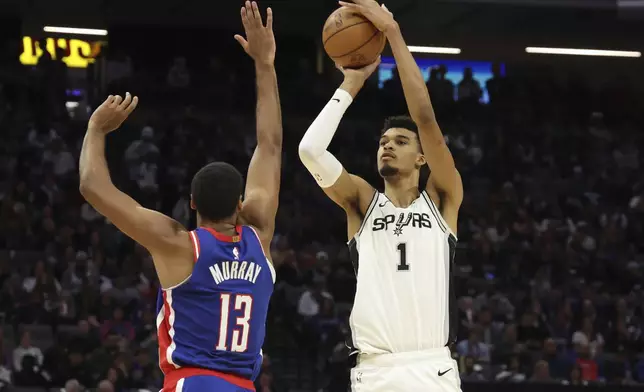 San Antonio Spurs center Victor Wembanyama (1) shoots over Sacramento Kings forward Keegan Murray (13) during the second half of an NBA basketball game in Sacramento, Calif, Sunday, Dec. 1, 2024. (AP Photo/Jed Jacobsohn)