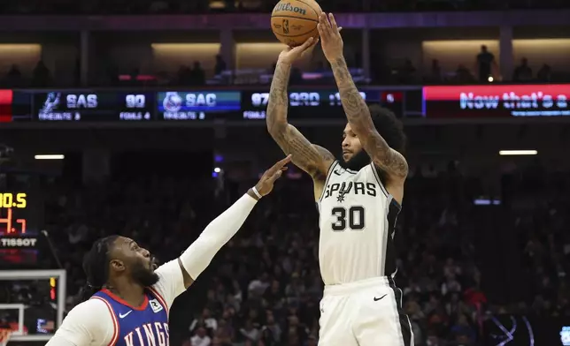 San Antonio Spurs forward Julian Champagnie (30) shoots against Sacramento Kings forward Jae Crowder (99) during the second half of an NBA basketball game in Sacramento, Calif, Sunday, Dec. 1, 2024. (AP Photo/Jed Jacobsohn)