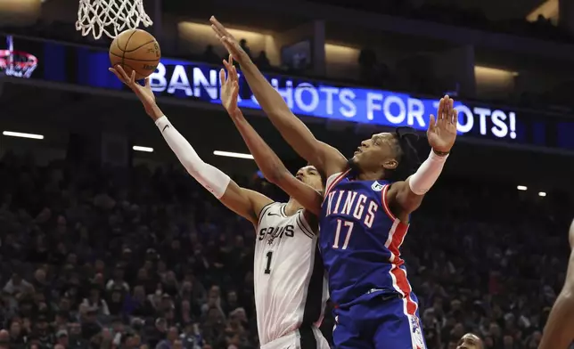 San Antonio Spurs center Victor Wembanyama (1) shoots against Sacramento Kings center Isaac Jones (17) during the second half of an NBA basketball game in Sacramento, Calif, Sunday, Dec. 1, 2024. (AP Photo/Jed Jacobsohn)