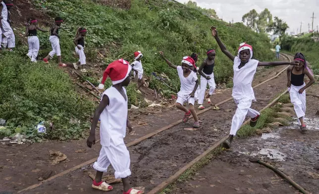 Young dancers run to go and perform at a Christmas ballet event in Kibera slum, one of the busiest neighborhoods of Kenya's capital, Nairobi, Kenya Saturday, Dec. 21, 2024. (AP Photo/Brian Inganga)