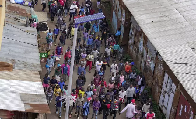 Children walk to attend a Christmas ballet event in Kibera slum, one of the busiest neighborhoods of Kenya's capital, Nairobi, Kenya Saturday, Dec. 21, 2024. (AP Photo/Brian Inganga)