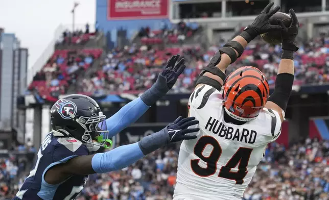 Cincinnati Bengals defensive end Sam Hubbard (94) catches a touchdown pass over Tennessee Titans linebacker James Williams during the first half of an NFL football game Sunday, Dec. 15, 2024, in Nashville, Tenn. (AP Photo/George Walker IV)