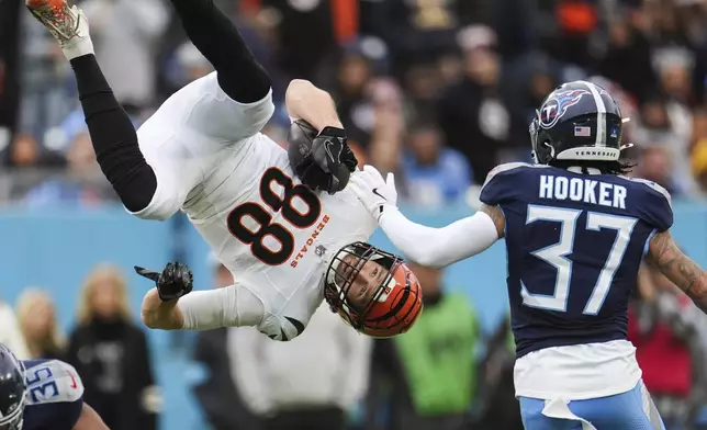 Cincinnati Bengals tight end Mike Gesicki (88) is flipped into the air by Tennessee Titans cornerback Daryl Worley (35) as safety Amani Hooker (37) looks on during the first half of an NFL football game Sunday, Dec. 15, 2024, in Nashville, Tenn. (AP Photo/George Walker IV)