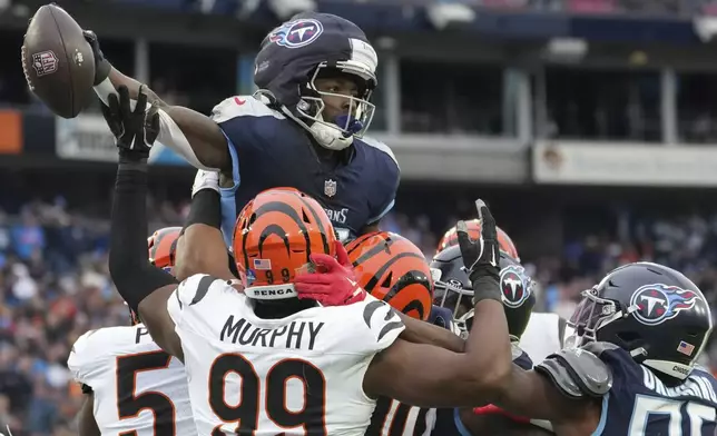 Tennessee Titans running back Tyjae Spears (2) scores a touchdown over the Cincinnati Bengals defense during the first half of an NFL football game Sunday, Dec. 15, 2024, in Nashville, Tenn. (AP Photo/George Walker IV)