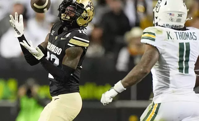 FILE - Colorado wide receiver Travis Hunter, left, pulls in a pass ahead of Baylor linebacker Keaton Thomas during the second half of an NCAA college football game Saturday, Sept. 21, 2024, in Boulder, Colo. (AP Photo/David Zalubowski, File)