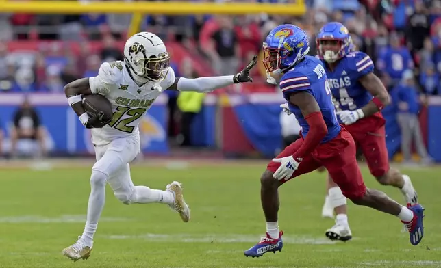 FILE - Colorado wide receiver Travis Hunter (12) pushes away Kansas cornerback Mello Dotson (3) as he runs for a first down during the first half of an NCAA college football game, Saturday, Nov. 23, 2024, in Kansas City, Mo. (AP Photo/Charlie Riedel, File)