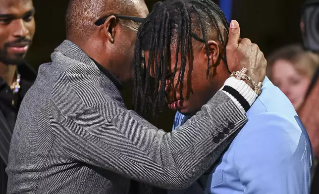 Colorado’s Travis Hunter, right, and coach Deion Sanders embrace after Hunter won the Heisman Trophy as the outstanding player in college football, Saturday, Dec. 14, 2024, in New York.(Todd Van Emst/Heisman Trust via AP, Pool)