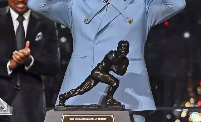 Colorado’s Travis Hunter gestures after winning the Heisman Trophy as the outstanding player in college football, Saturday, Dec. 14, 2024, in New York.(Todd Van Emst/Heisman Trust via AP, Pool)