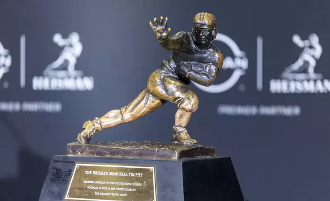 The Heisman Trophy is displayed before the finalists spoke at a college football press conference, Saturday, Dec. 14, 2024, in New York. (AP Photo/Corey Sipkin)