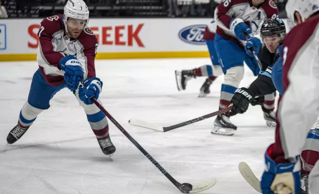 Colorado Avalanche defenseman Devon Toews (7) grabs the puck as Utah Hockey Club center Clayton Keller (9) defends during the first period of an NHL hockey game Friday, Dec. 27, 2024, in Salt Lake City. (AP Photo/Rick Egan)