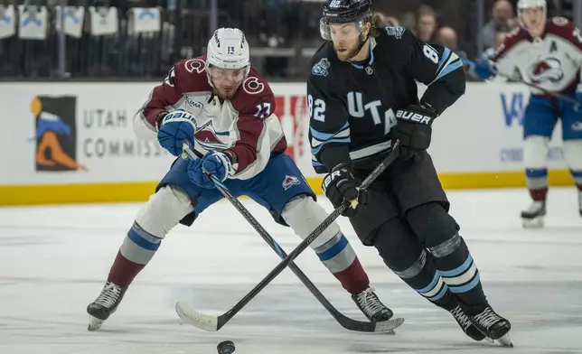 Colorado Avalanche right wing Valeri Nichushkin (13) and Utah Hockey Club center Kevin Stenlund (82) go after the puck, during the first period of an NHL hockey game Friday, Dec. 27, 2024, in Salt Lake City. (AP Photo/Rick Egan)