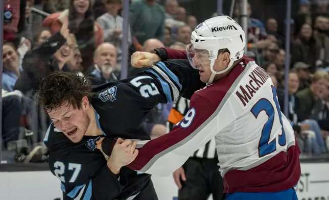 Utah Hockey Club center Barrett Hayton (27) and Colorado Avalanche center Nathan MacKinnon (29) get into a scuffle during the second period of an NHL hockey game Friday, Dec. 27, 2024, in Salt Lake City. (AP Photo/Rick Egan)