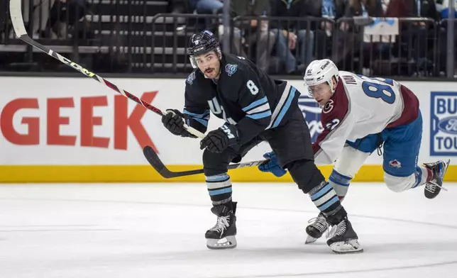 Utah Hockey Club center Nick Schmaltz (8) and Colorado Avalanche center Ivan Ivan (82) battle for position during the second period of an NHL hockey game Friday, Dec. 27, 2024, in Salt Lake City. (AP Photo/Rick Egan)