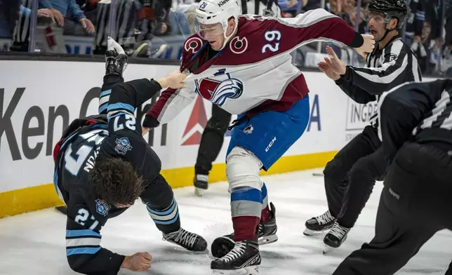 Utah Hockey Club center Barrett Hayton (27) and Colorado Avalanche center Nathan MacKinnon (29) get into a scuffle during the second period of an NHL hockey game Friday, Dec. 27, 2024, in Salt Lake City. (AP Photo/Rick Egan)