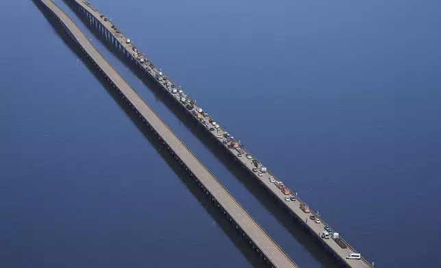 Disabled vehicles and response vehicles are seen on the Lake Pontchartrain Causeway, which spans 24 miles over the lake, after a pileup due to morning fog in New Orleans, Tuesday, Dec. 17, 2024. (AP Photo/Gerald Herbert)
