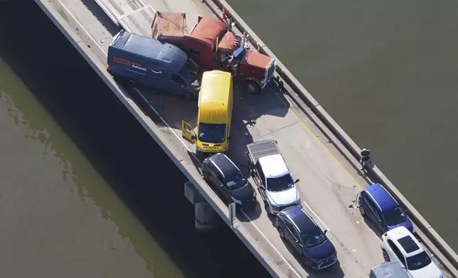Disabled vehicles and response vehicles are seen on the Lake Pontchartrain Causeway, which spans 24 miles over the lake, after a pileup due to morning fog in New Orleans, Tuesday, Dec. 17, 2024. (AP Photo/Gerald Herbert)