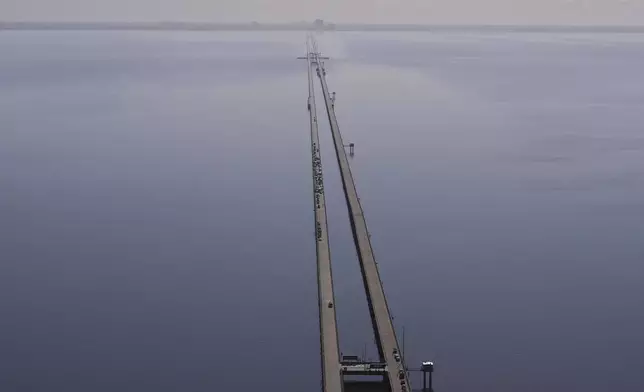 Disabled vehicles and response vehicles are seen on the Lake Pontchartrain Causeway, which spans 24 miles over the lake, after a pileup due to morning fog in New Orleans, Tuesday, Dec. 17, 2024. (AP Photo/Gerald Herbert)