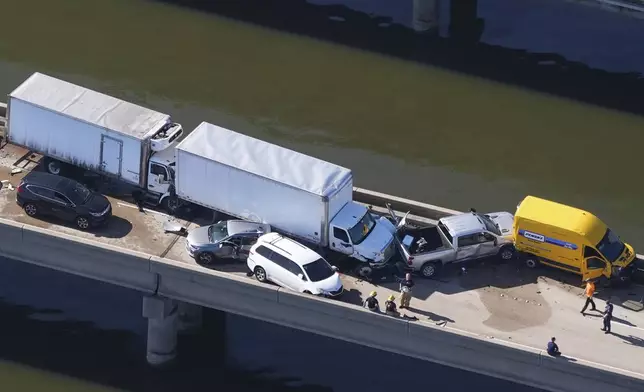 Disabled vehicles and response vehicles are seen on the Lake Pontchartrain Causeway, which spans 24 miles over the lake, after a pileup due to morning fog in New Orleans, Tuesday, Dec. 17, 2024. (AP Photo/Gerald Herbert)