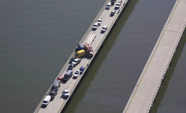 Disabled vehicles and response vehicles are seen on the Lake Pontchartrain Causeway, which spans 24 miles over the lake, after a pileup due to morning fog in New Orleans, Tuesday, Dec. 17, 2024. (AP Photo/Gerald Herbert)