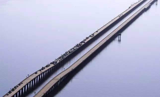 Disabled vehicles and response vehicles are seen on the Lake Pontchartrain Causeway, which spans 24 miles over the lake, after a pileup due to morning fog in New Orleans, Tuesday, Dec. 17, 2024. (AP Photo/Gerald Herbert)