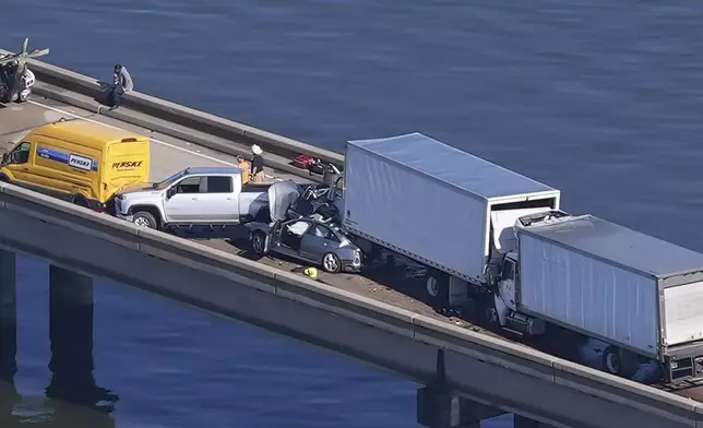 Disabled vehicles and response vehicles are seen on the Lake Pontchartrain Causeway, which spans 24 miles over the lake, after a pileup due to morning fog in New Orleans, Tuesday, Dec. 17, 2024. (AP Photo/Gerald Herbert)