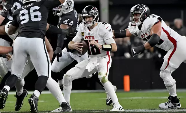 Atlanta Falcons quarterback Kirk Cousins (18) is pressured by Las Vegas Raiders defensive end K'Lavon Chaisson (44) during the first half of an NFL football game, Monday, Dec. 16, 2024, in Las Vegas. (AP Photo/David Becker)