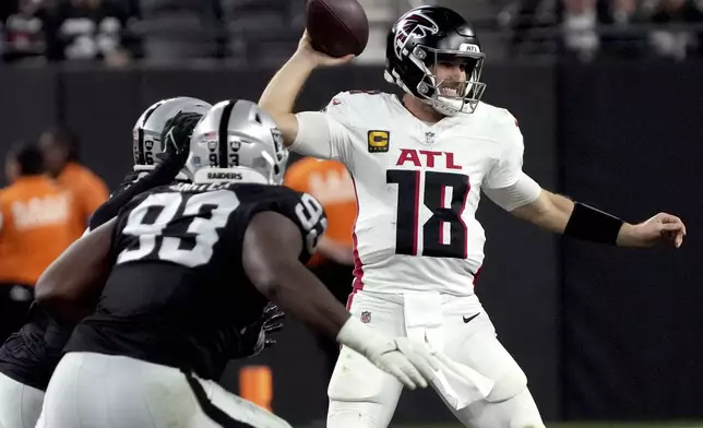 Atlanta Falcons quarterback Kirk Cousins (18) looks to throw as Las Vegas Raiders defensive tackle Zach Carter (93) pursues during the second half of an NFL football game, Monday, Dec. 16, 2024, in Las Vegas. (AP Photo/Rick Scuteri)