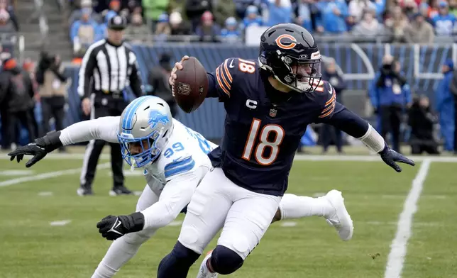 Chicago Bears quarterback Caleb Williams escapes the pressure of Detroit Lions defensive end Za'Darius Smith during the first half of an NFL football game Sunday, Dec. 22, 2024, in Chicago. (AP Photo/Nam Y. Huh)