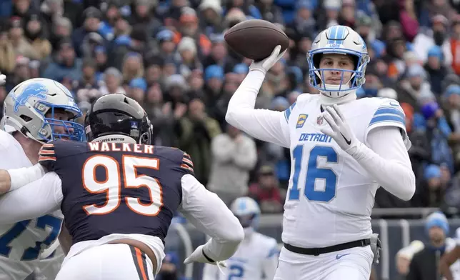 Detroit Lions quarterback Jared Goff passes under pressure from Chicago Bears defensive end DeMarcus Walker during the first half of an NFL football game Sunday, Dec. 22, 2024, in Chicago. (AP Photo/Nam Y. Huh)