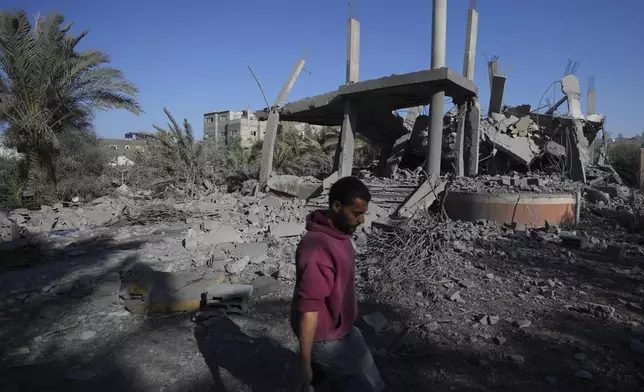 A Palestinian walks past a destroyed building following an overnight Israeli strike in Deir al-Balah, Gaza Strip, Wednesday, Dec. 4, 2024. (AP Photo/Abdel Kareem Hana)